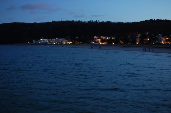 Aussicht von der Seebrücke auf die Lichter des Fischerstrands bei Dunkelheit